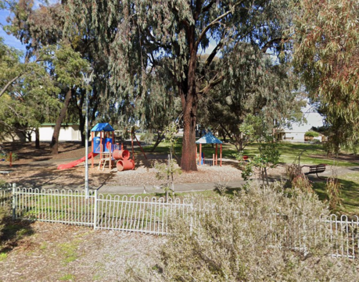 Small playground surrounded by trees