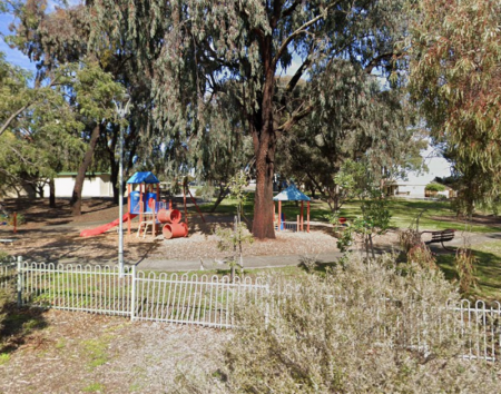 Small playground surrounded by trees