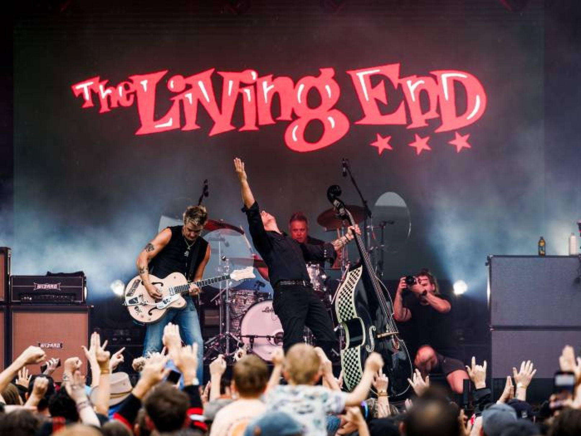 Musicians from The Living End performing on stage