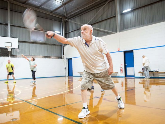 Man playing a racquet sport indoors