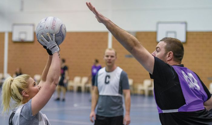 Men and women playing netball together