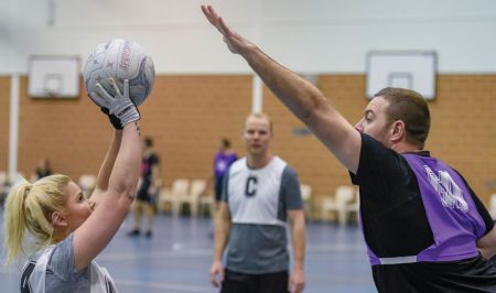 Men and women playing netball together