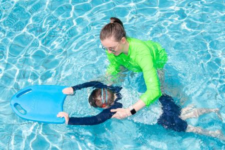Swimming instructor teaching a child