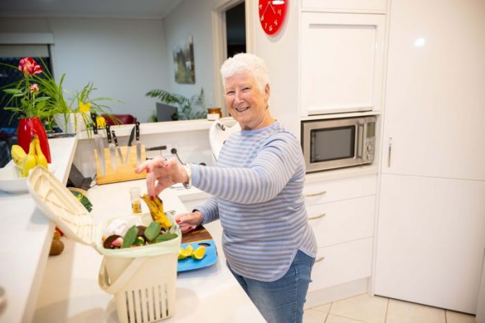Resident placing food scraps into mini muncher