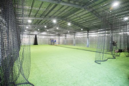 Interior of large shed set up for baseball training