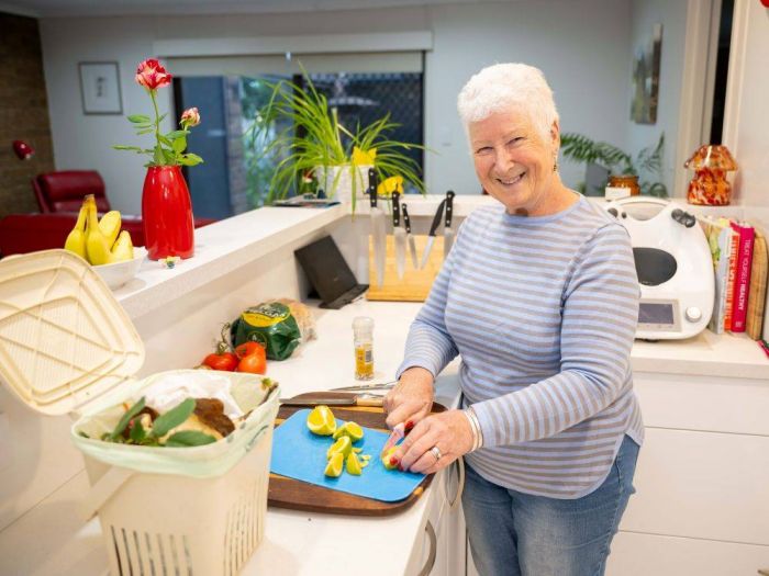 Person in kitchen with compost caddy
