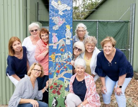 Group of artists with mosaic stobie pole art