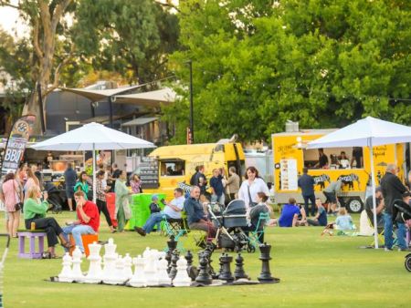 Giant chess set with food trucks in background