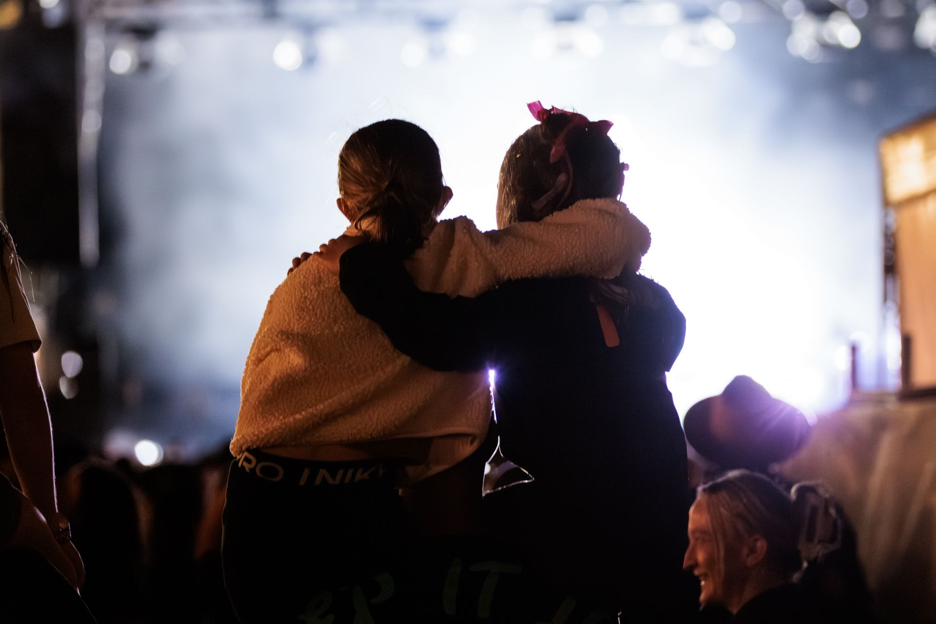 Two young people facing a music event stage