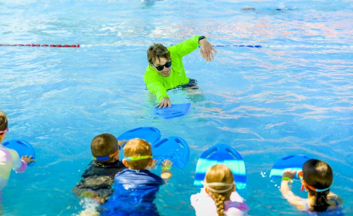 Swimming instructor teaching children