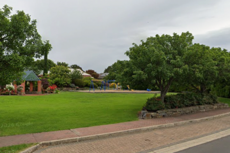 Playground surrounded by grassed area and trees